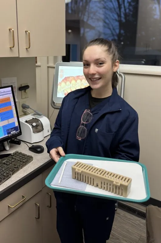 Mia - dental employee looking at the camera standing in an exam room