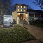Timeless Family Dental exterior at dusk, lit sign and entrance.